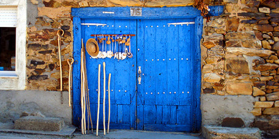Beautiful blue wooden door with pilgrim staffs and scallop shells on the Camino de Santiago